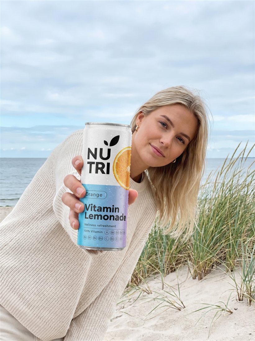 Young woman with NUTRI Orange at the Baltic seaside